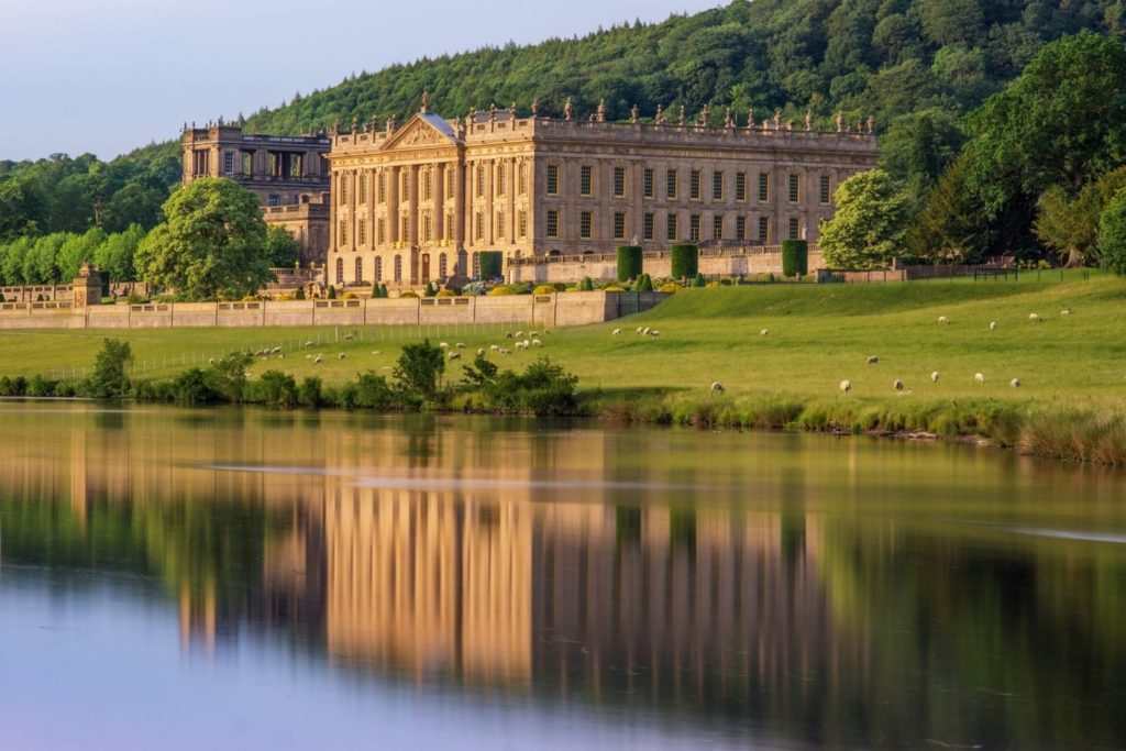 Elegant luxury cottage with stunning gardens, reflecting lake views, and classic architectural design amidst lush greenery